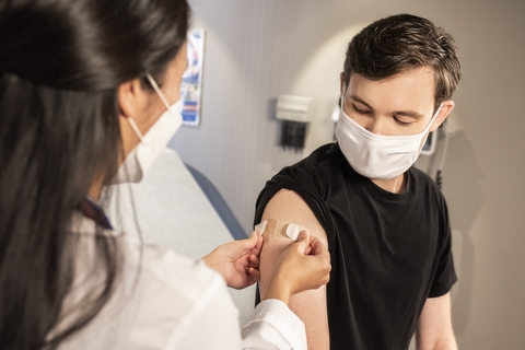 Persoon krijgt een pleister van een zorgverlener